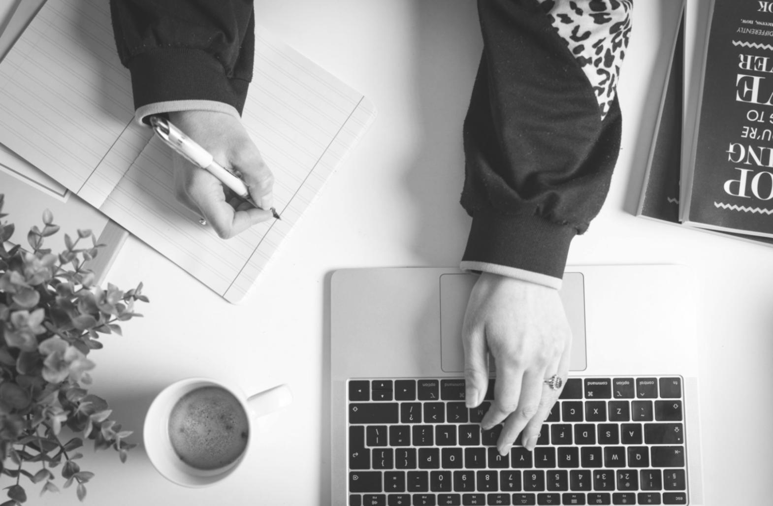 Person working calmly on laptop with financial planning materials, representing balanced approach to money management